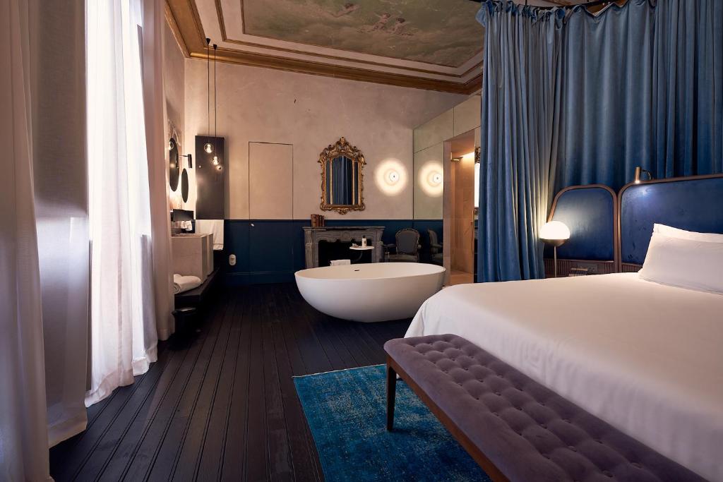 a hotel room with a bed and a bath tub at Can Bordoy Grand House & Garden in Palma de Mallorca