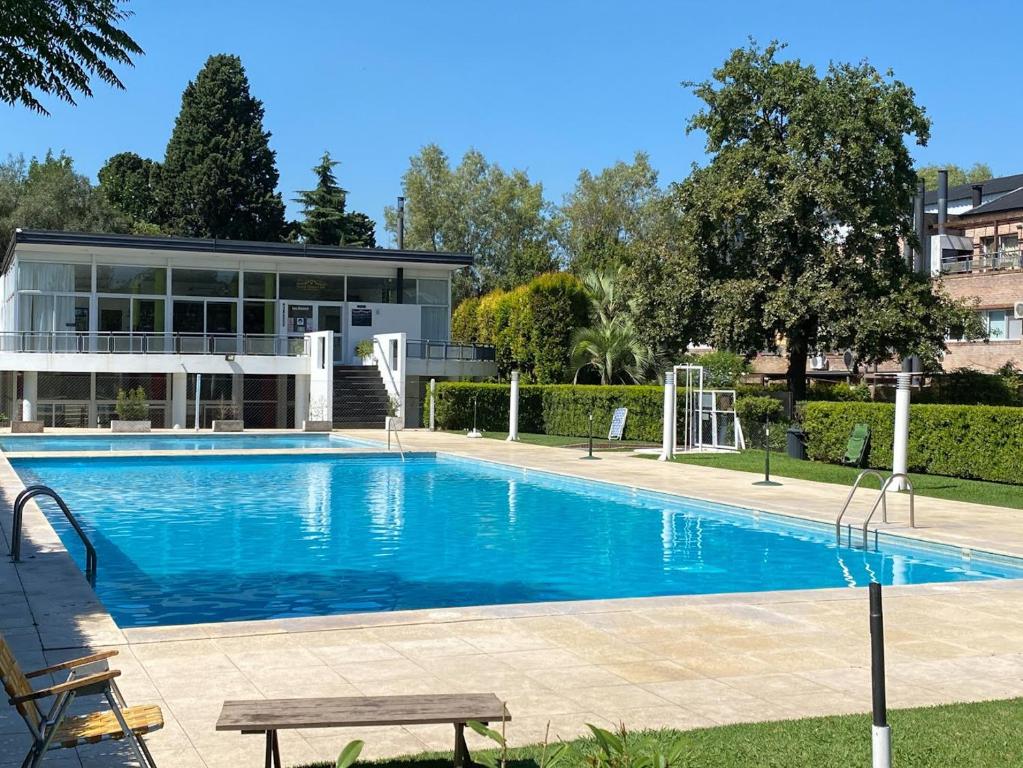 una piscina frente a un edificio en Apartamento en Country Pilar Piscina Parrilla propia hasta 4 personas en Pilar