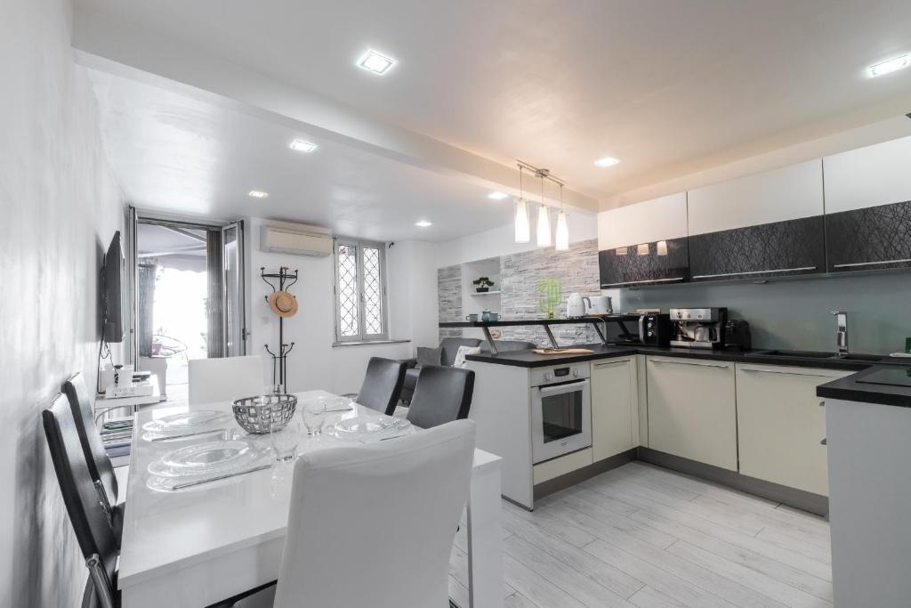 une cuisine blanche avec une table et des chaises dans l'établissement Amazing 3 Bdrs and Garden Place du Pin Parking !, à Nice