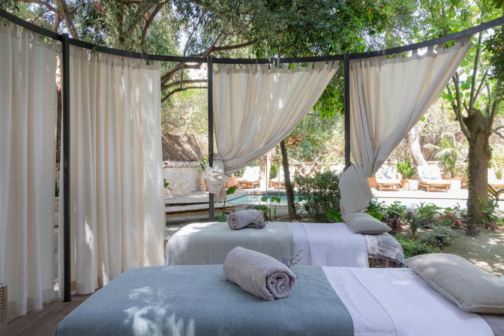 马略卡岛帕尔马Can Bordoy Grand House Hotel GL Preferred Hotel的配有白色窗帘的客房内的两张床