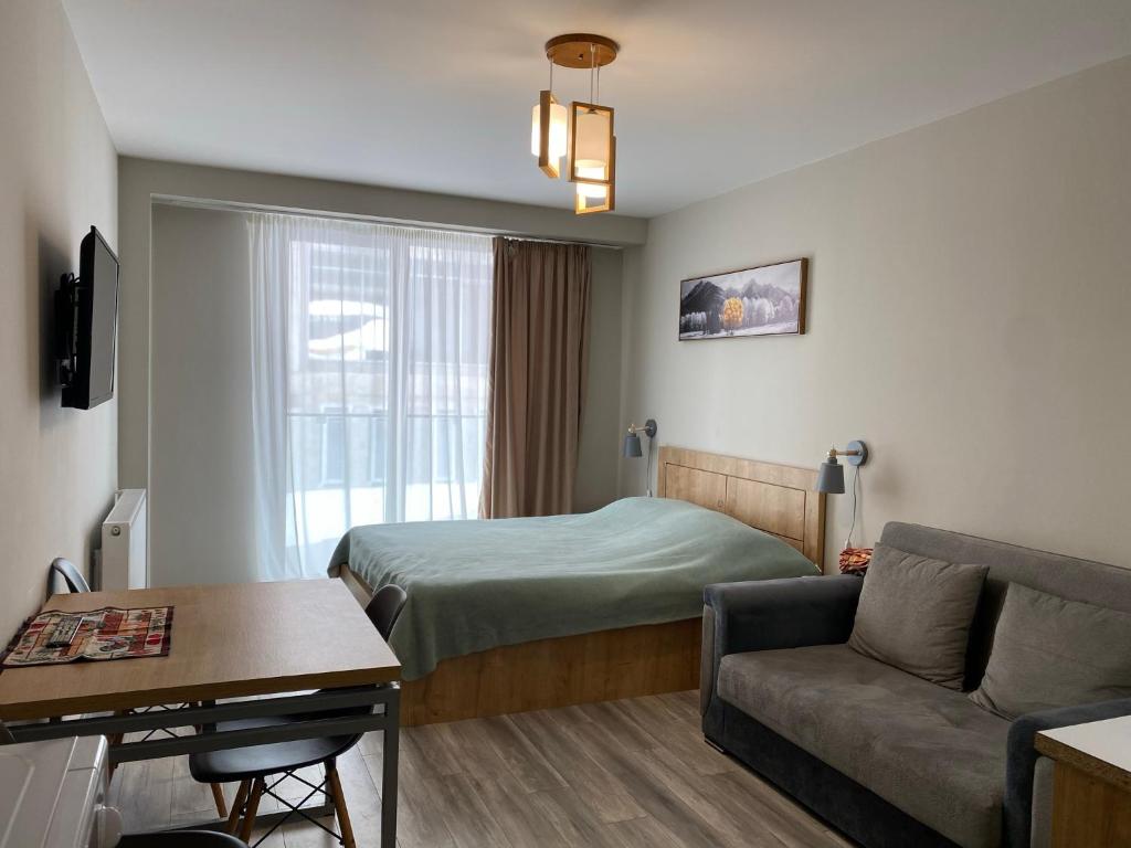a hotel room with a bed and a couch at New Gudauri Loft 2 - "Mano", near ski lift Gondola in Gudauri