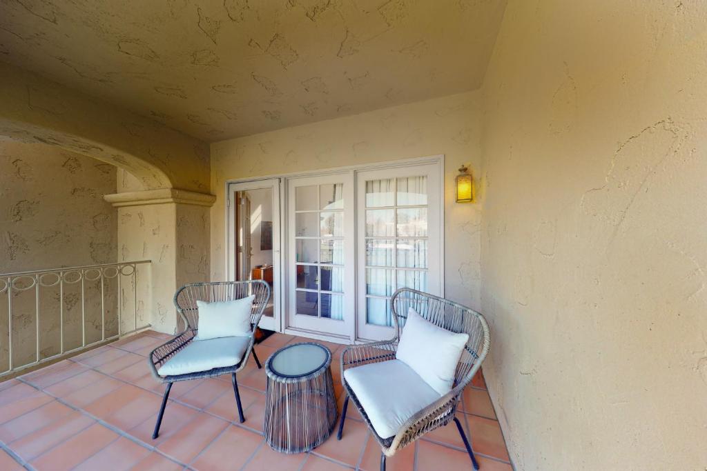 a balcony with two chairs and a table at Desert Sunset Serenity in Phoenix