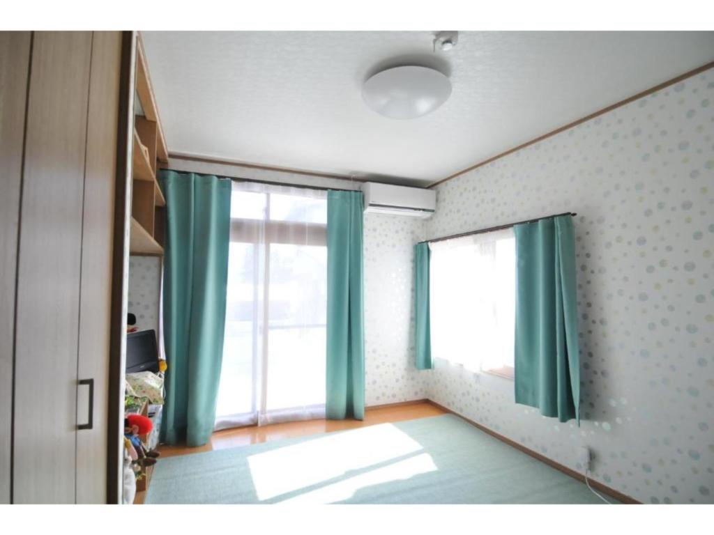 にあるDaichan Farm Guest House - Vacation STAY 19124vの緑のカーテンと大きな窓が備わる客室です。