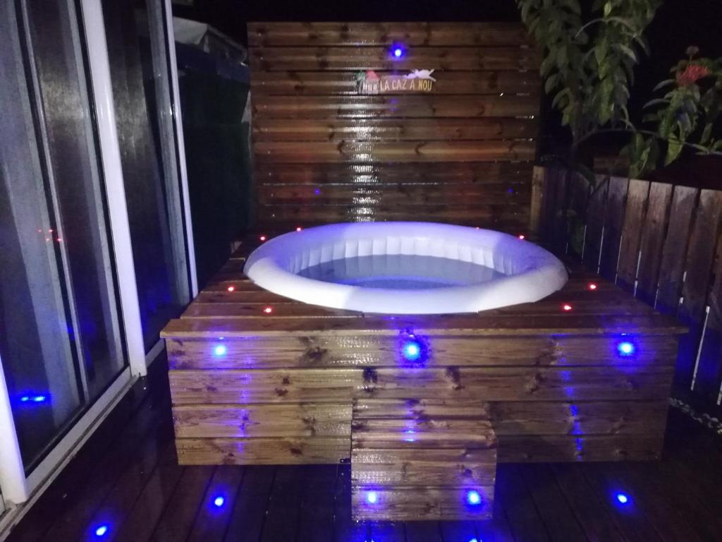 a jacuzzi tub with christmas lights on a deck at La CAZ A NOU in Saint-Pierre