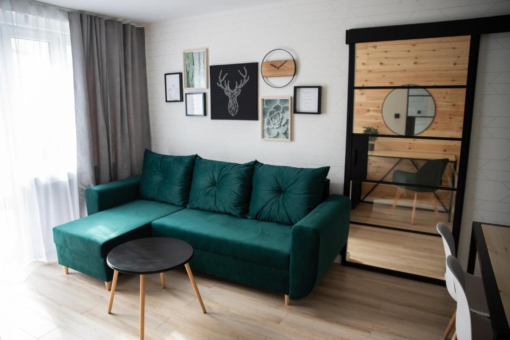 salon z zieloną kanapą i stołem w obiekcie Green Loft Apartament w Białej Podlaskiej