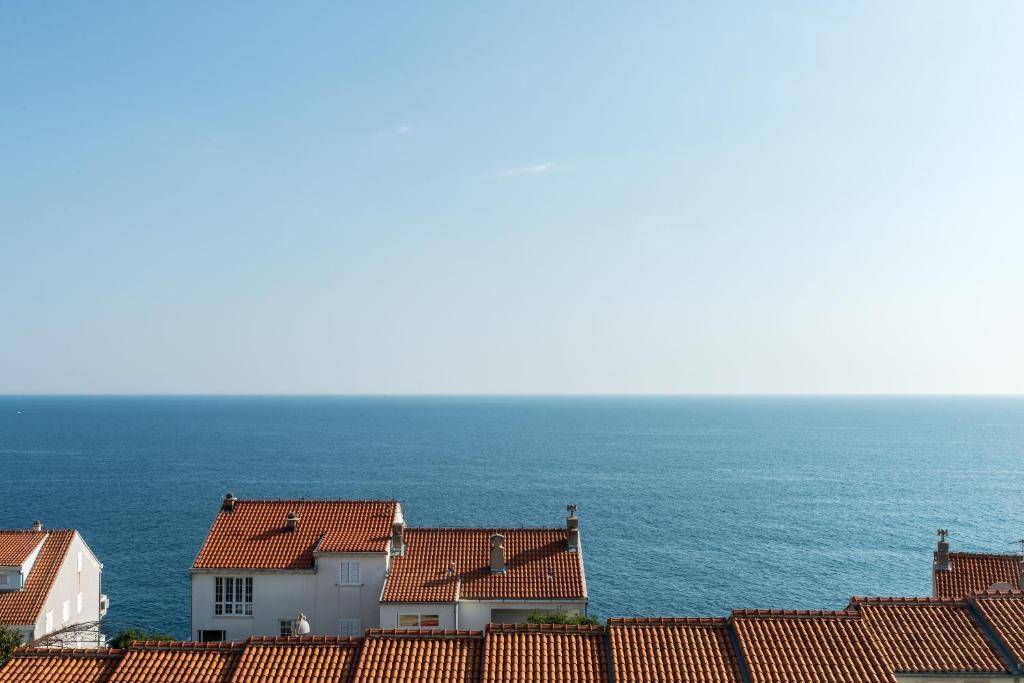 una fila de casas con el océano en el fondo en Apartment Mia, en Dubrovnik