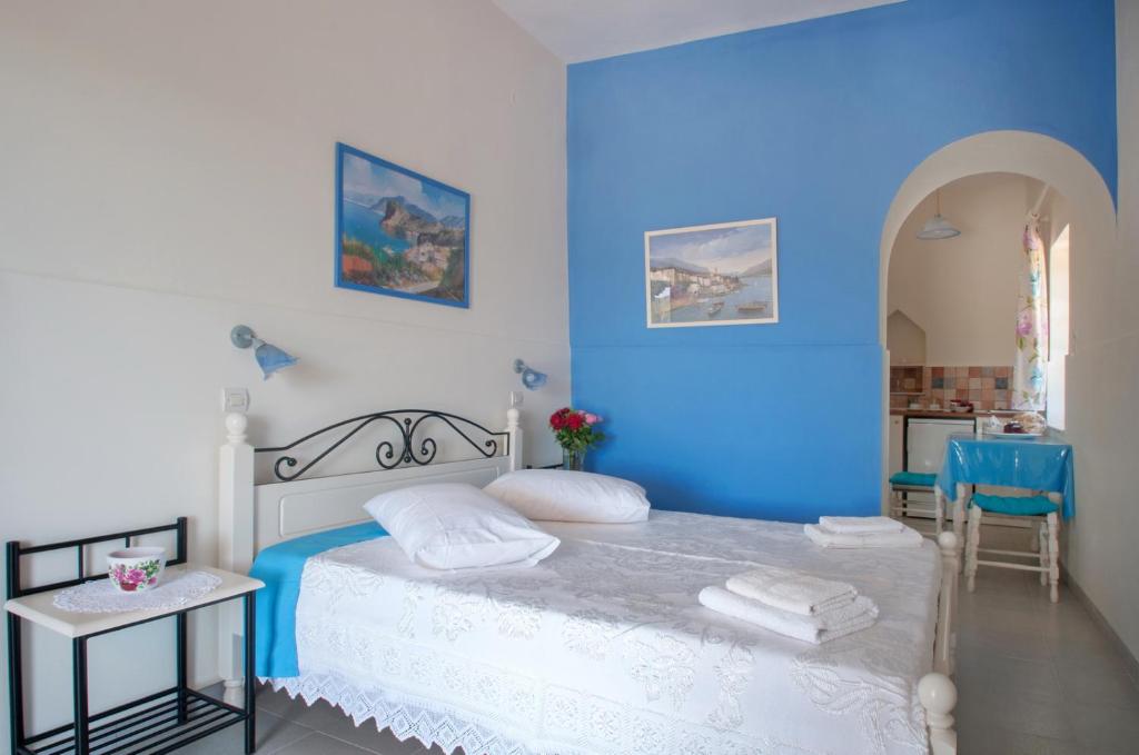 a blue bedroom with a bed with towels on it at Filio rooms in Kýthira