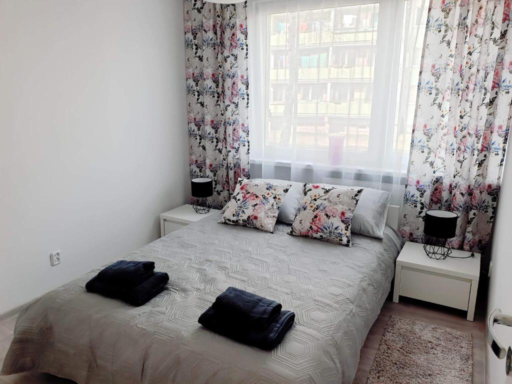 a bedroom with a bed with two pillows and a window at POKOJE GOŚCINNE UZDROVISCO CIEPLICE in Jelenia Góra