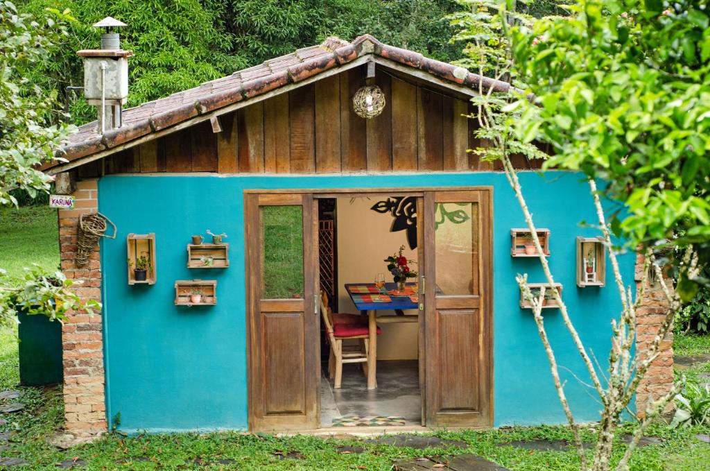 un petit hangar bleu avec une table. dans l'établissement Karunâ, à Visconde de Mauá