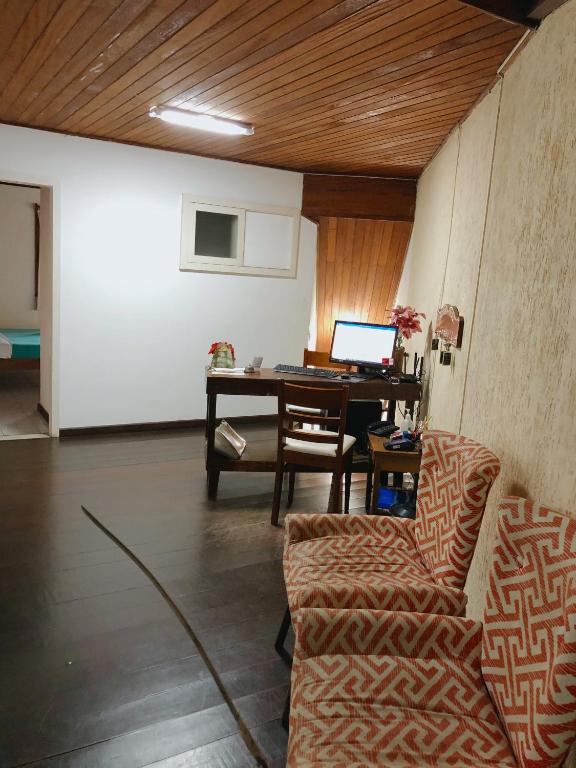 布希奧斯的住宿－Anexo Aldeia Búzios，客厅配有桌子和带笔记本电脑的书桌