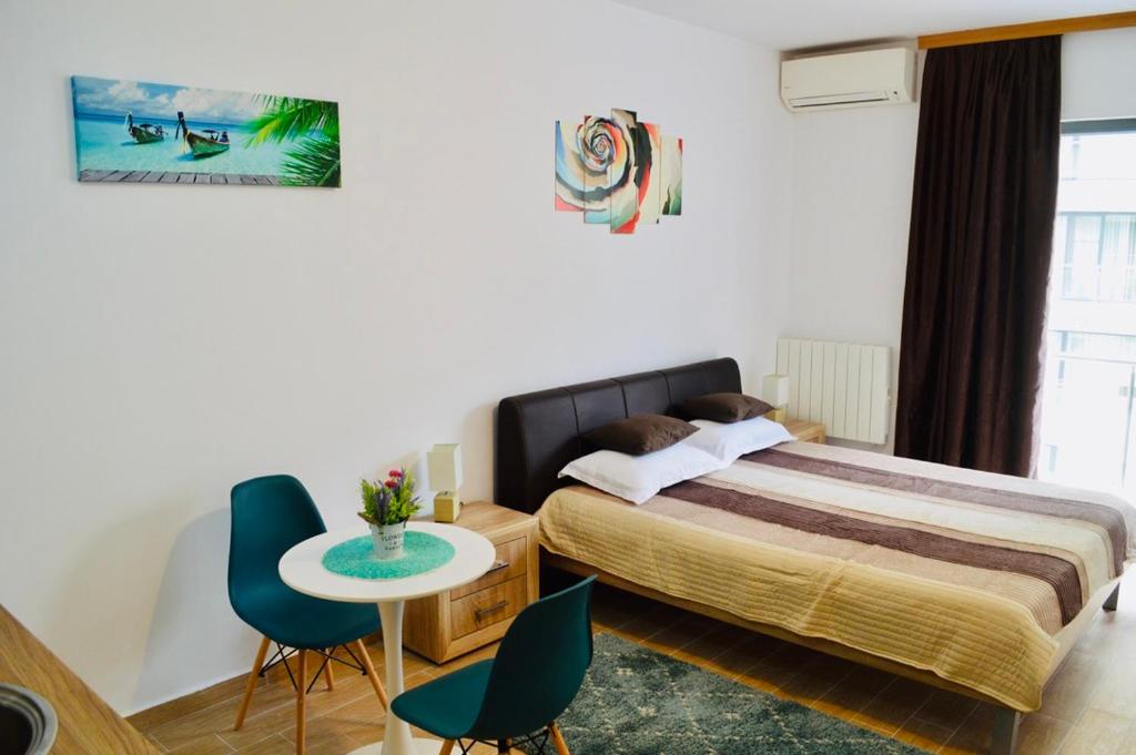 sypialnia z łóżkiem, stołem i krzesłami w obiekcie Studio Escape Mamaia next by LOFT w Mamai
