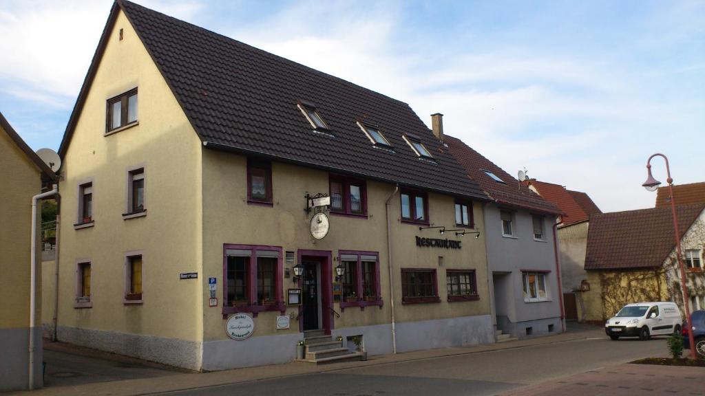 a building with a black roof on a street at Hotel Kraichgauidylle in Malsch