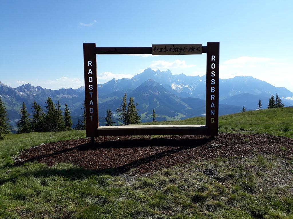 a sign on a hill with mountains in the background at Wellnesshaus Reichelt in Radstadt