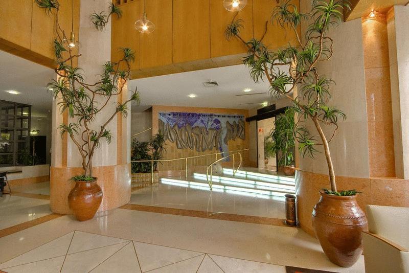 A plant-filled lobby beside a short illuminated stairway.