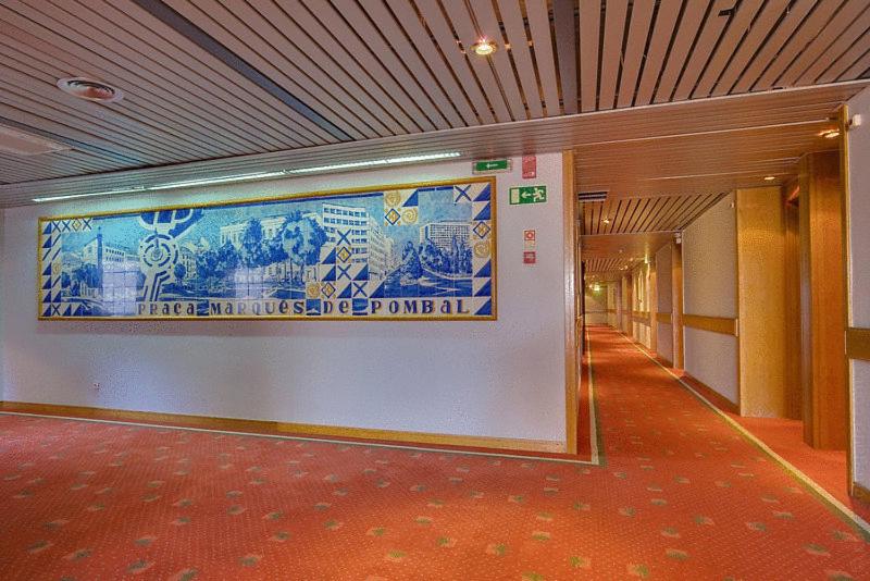 A carpeted hotel corridor with a large Portuguese-themed mural.