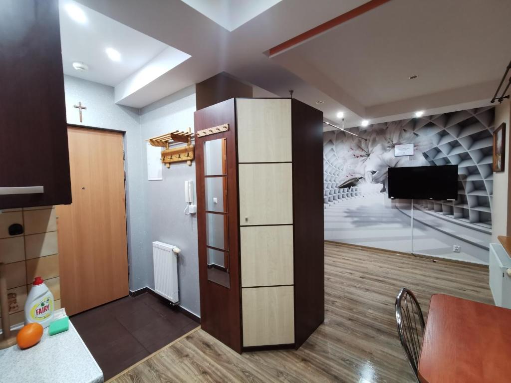 - un salon avec une télévision et un mur dans l'établissement APARTAMENT CIEŃ GIEWONTU, à Zakopane