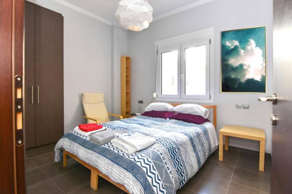 a bedroom with a bed with a blue and white blanket at Modern apartment in the heart of the city in Larisa