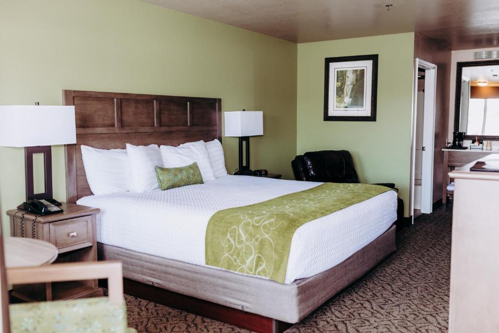 a hotel room with a large bed and a desk at Pacific Inn Motel in Forks