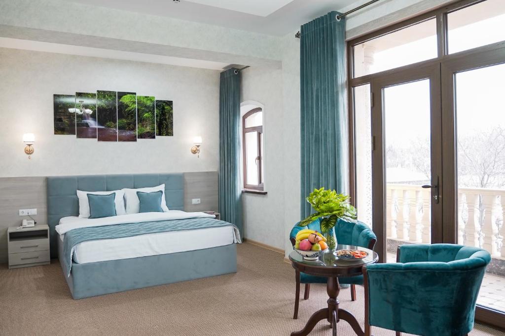 タシュケントにあるLevel Hotelのベッドルーム1室(ベッド1台、テーブル、椅子付)