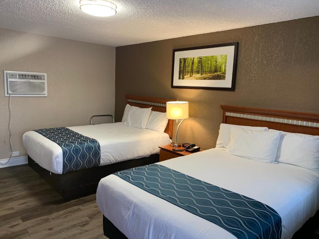 a hotel room with two beds and a lamp at Champlain Motor Inn in Pembroke