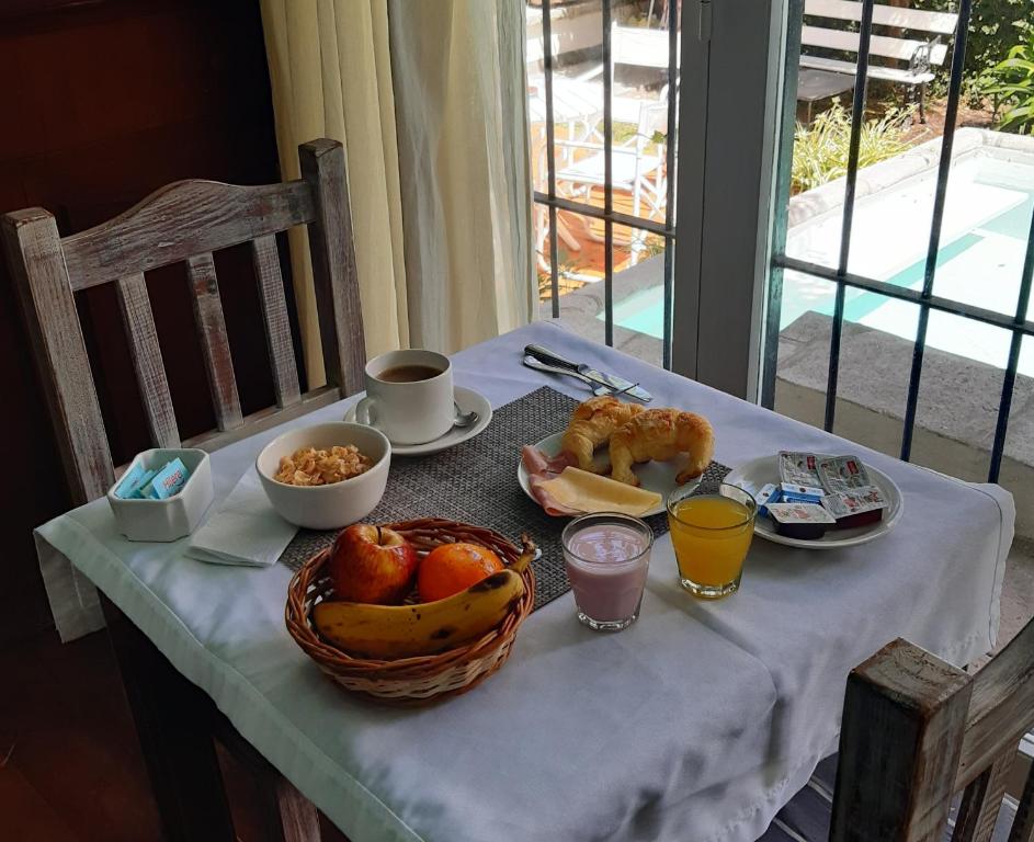 a table with breakfast foods and a basket of fruit at Casa Garay 602 in Mar del Plata