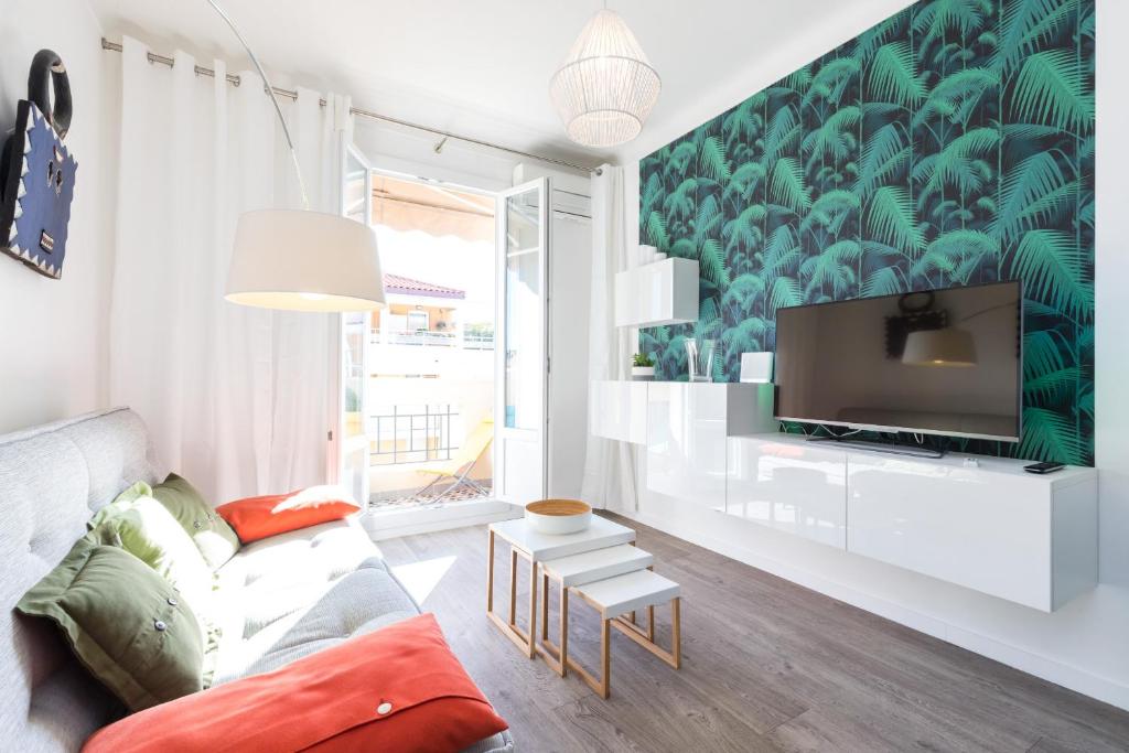 un salon avec un canapé et une télévision dans l'établissement Cosy 1 Bdr near Garibaldi Square - Top Floor & AC, à Nice