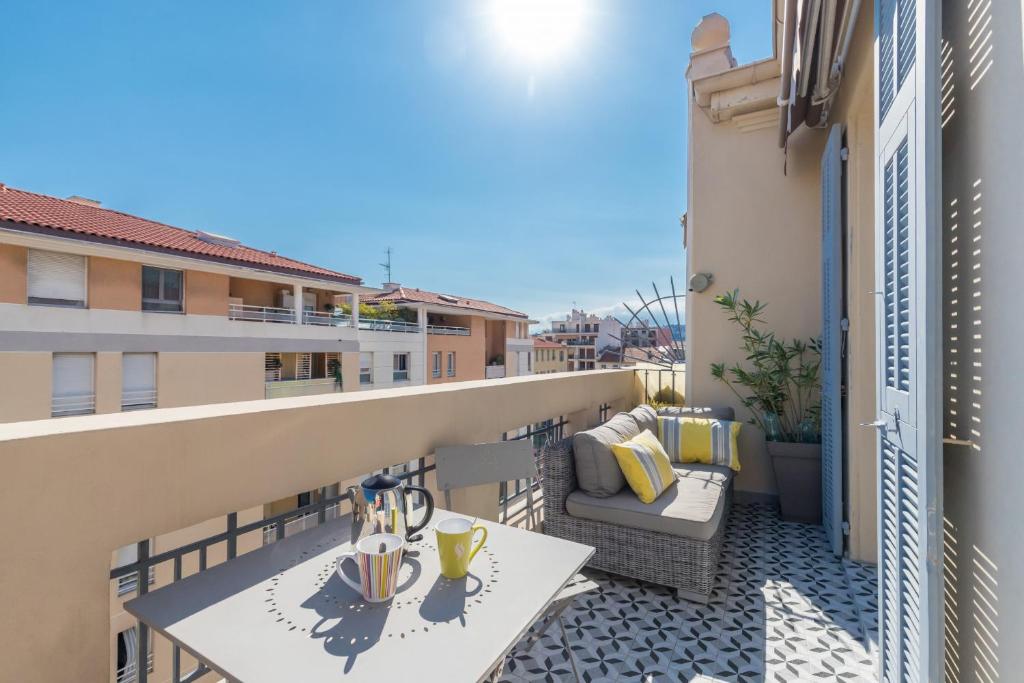- un balcon avec une table et une chaise dans un bâtiment dans l'établissement Cosy 2 Bdrs-Terrace near GaribaldiVieux NicePort, à Nice