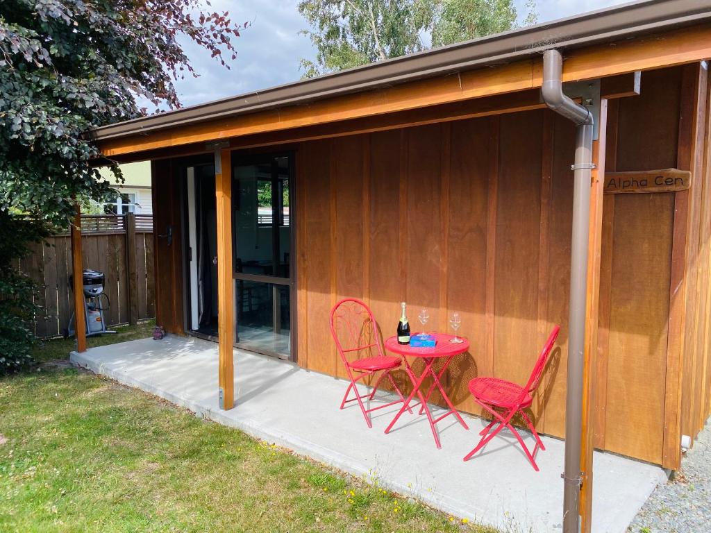 un patio con 2 sillas y una mesa en una casa en Star Cottages en Lake Tekapo