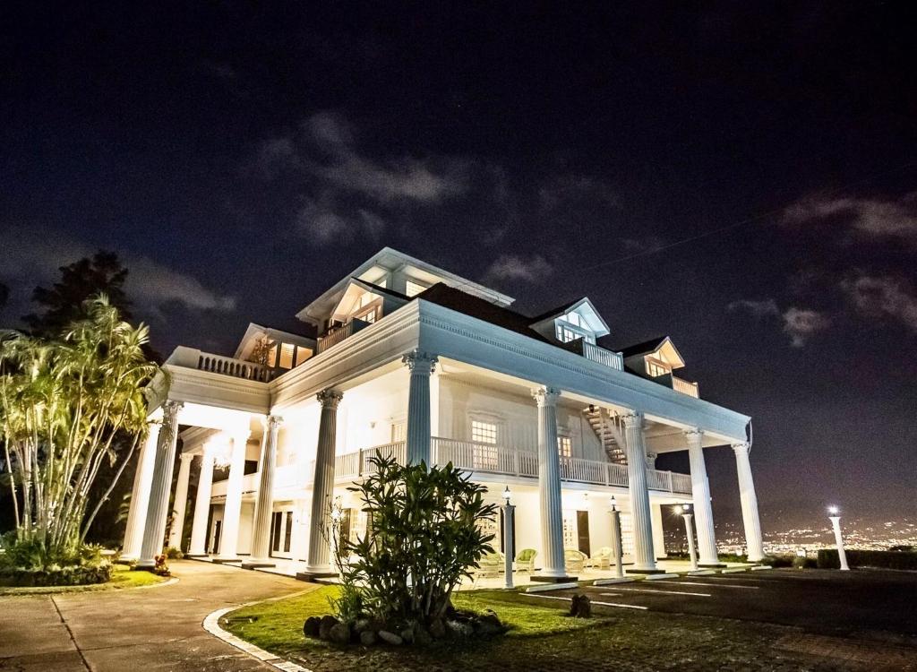 a large white building with columns at night at Fogo Resort in Escazu