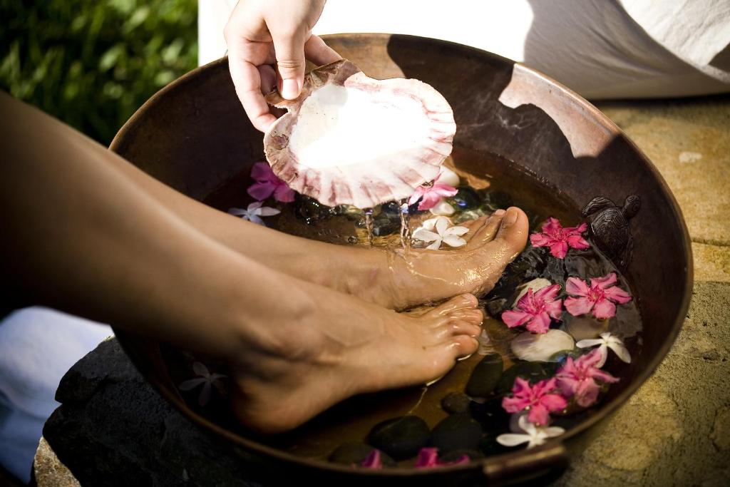 a woman is washing her feet in a pot of water at Cabo Surf Hotel in San José del Cabo
