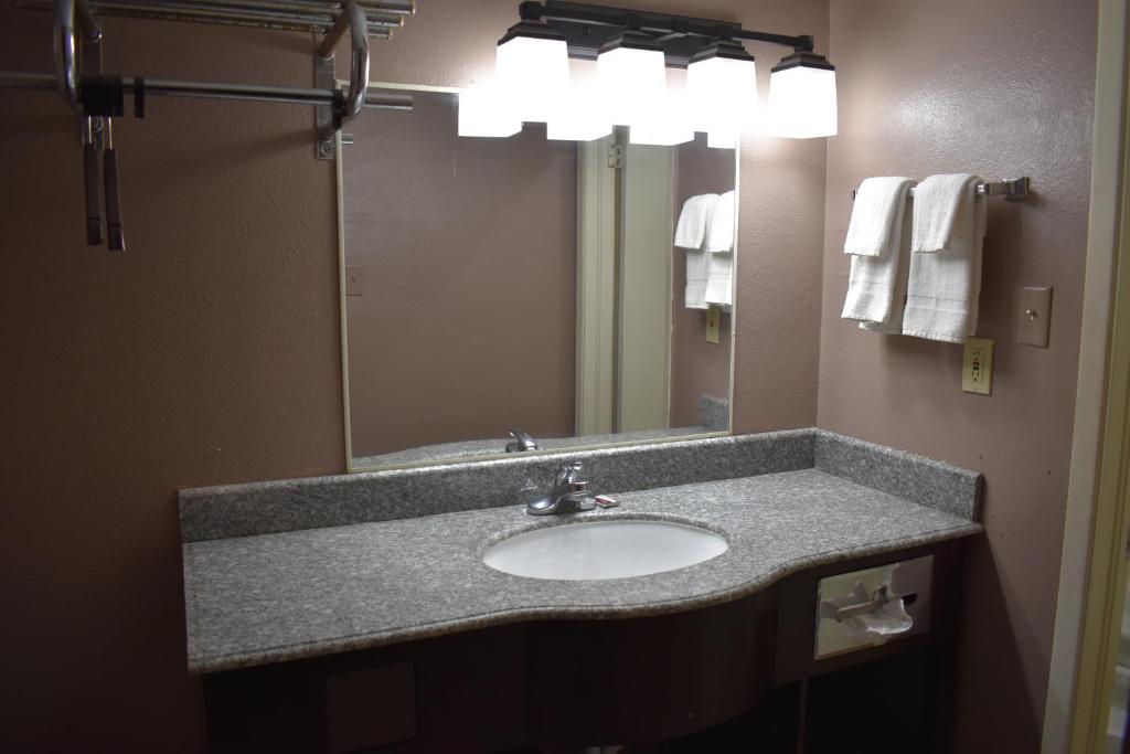 a bathroom with a sink and a mirror at Satellite Inn in Alamogordo