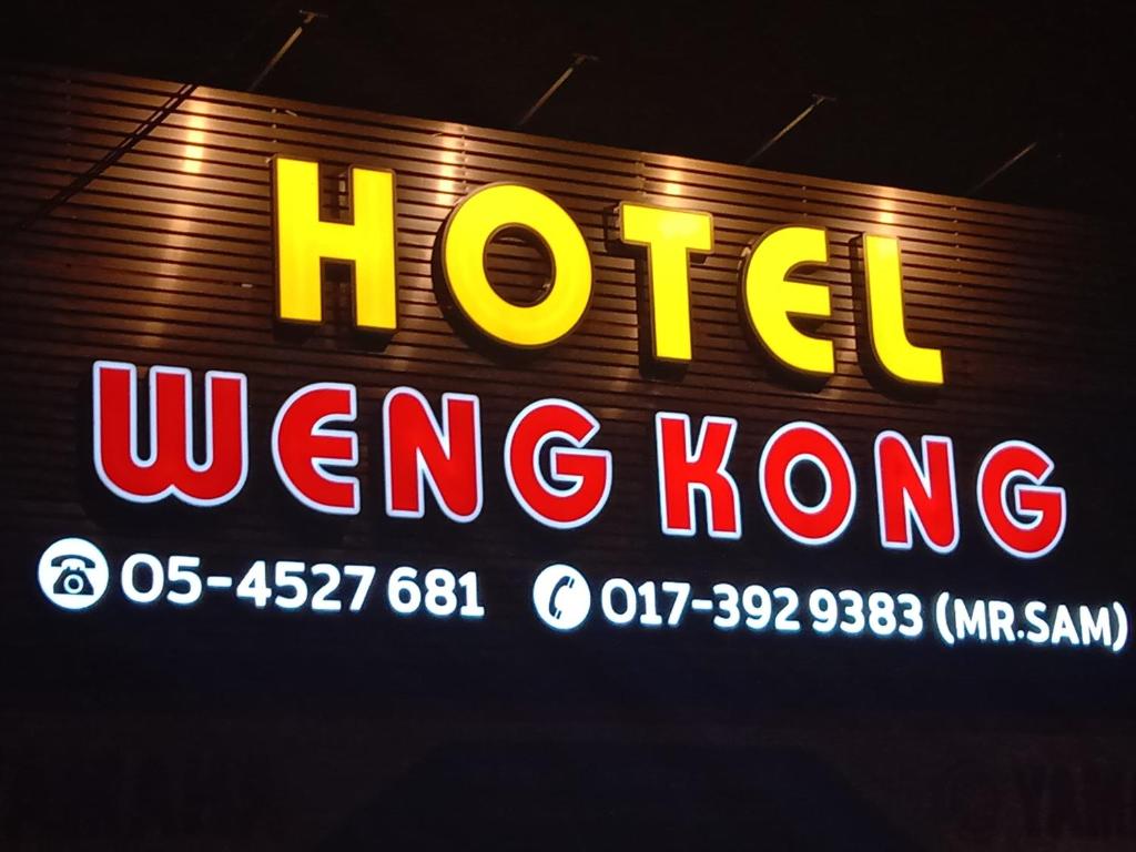 um sinal que diz hotel winging hong kong em Weng Kong Hotel em Slim River