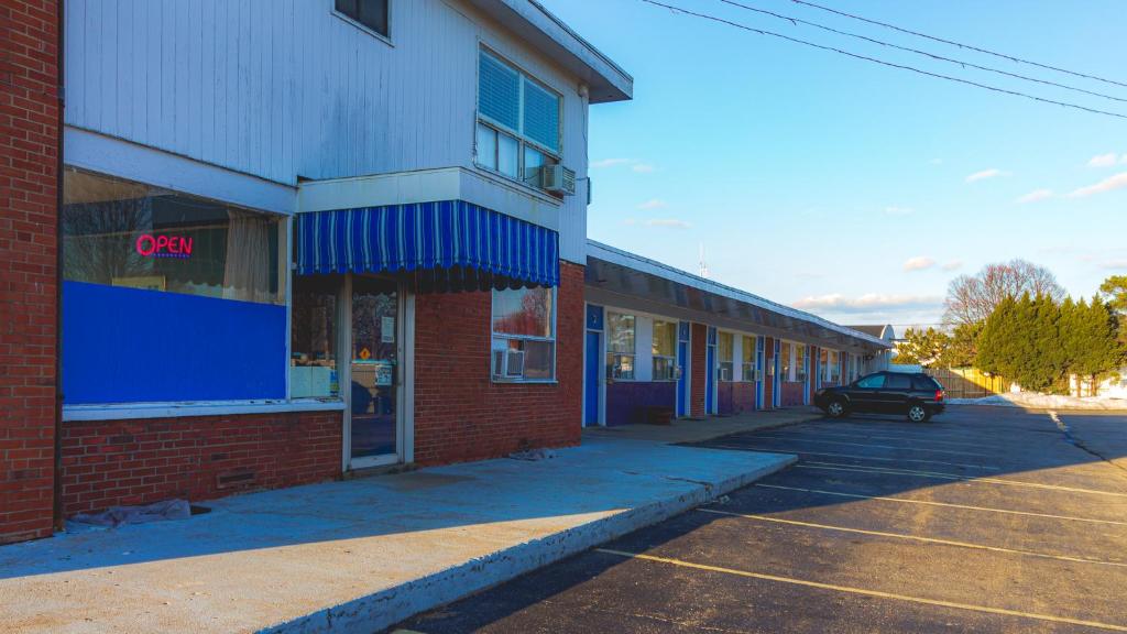 een auto geparkeerd voor een bakstenen gebouw bij Red Horse Motel Dayton Moraine in Dayton