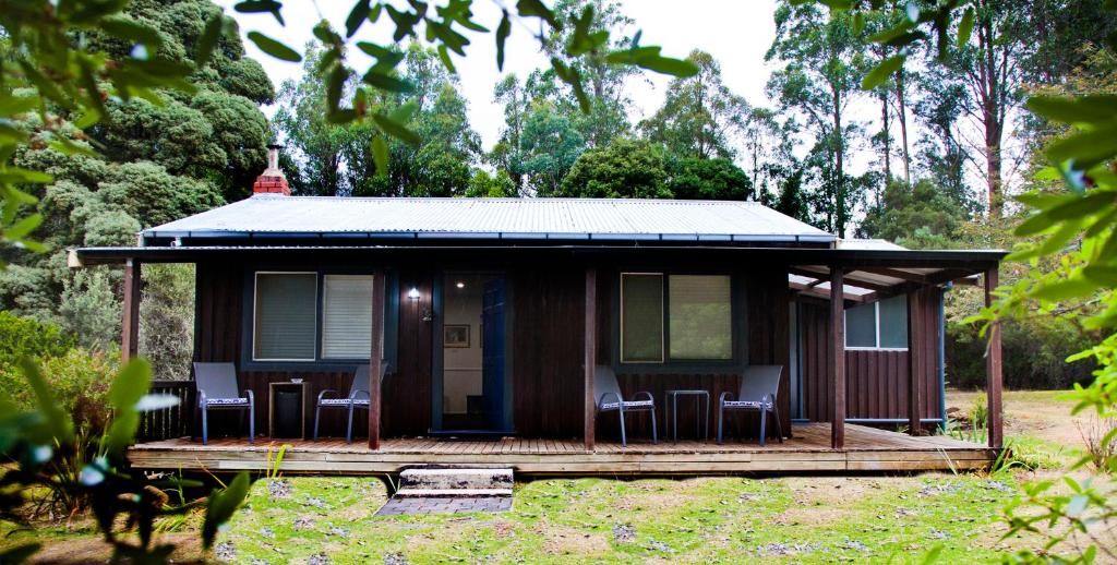 a small house with chairs on a porch at Tyenna River Cottages in Tyenna