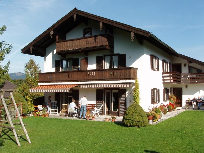 a large house with people standing outside of it at Haus Auracher in Unterwössen