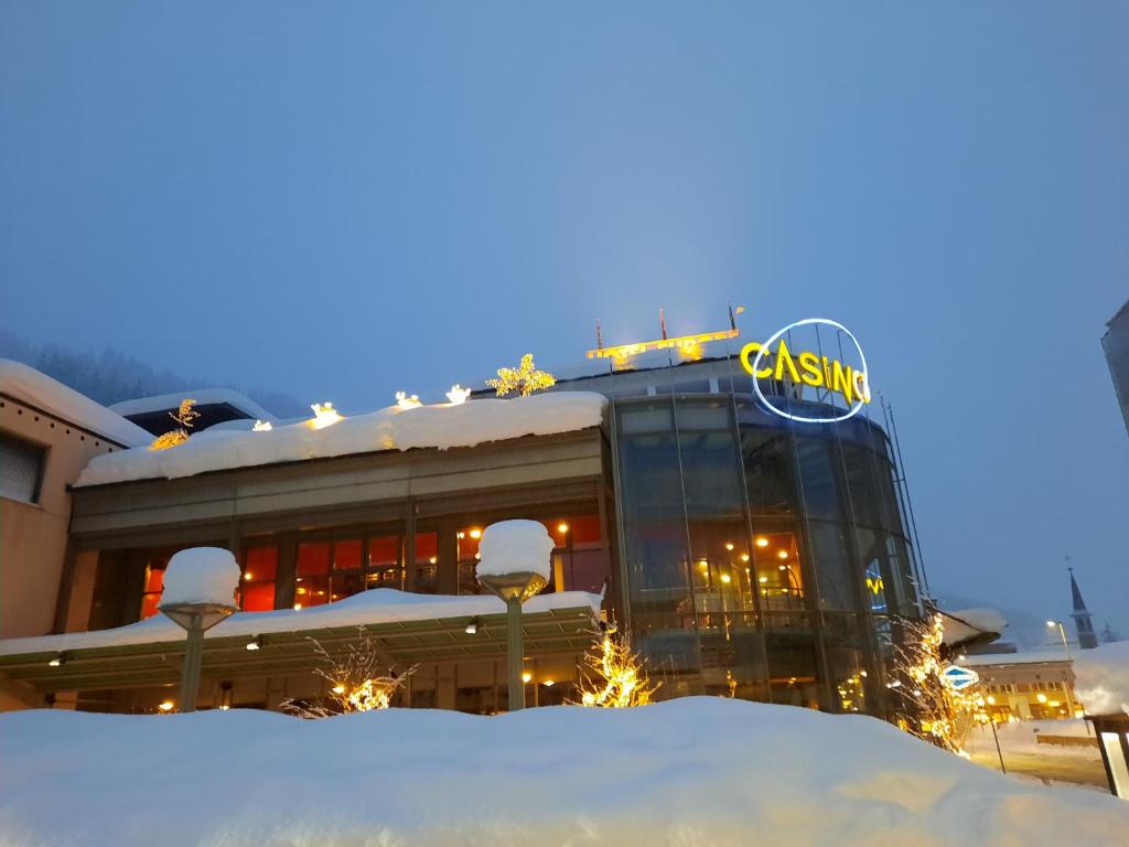 un edificio de casino con nieve delante en Holiday Apartment Davos Residence en Davos