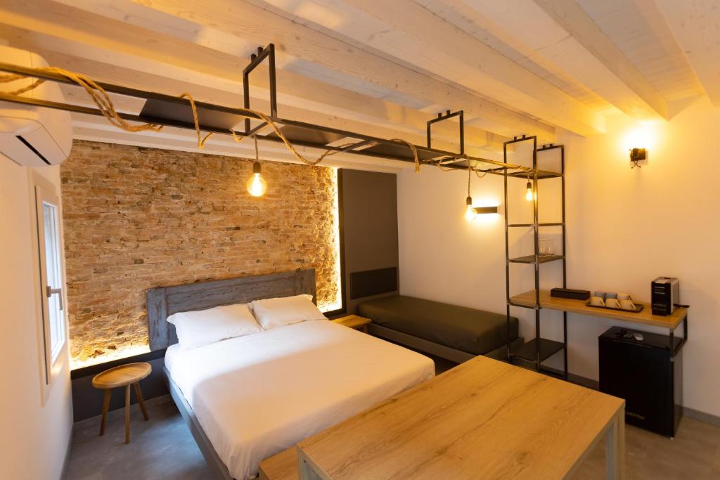 ein Schlafzimmer mit einem Bett und einem Sofa in einem Zimmer in der Unterkunft Casa San Cristoforo in Chioggia