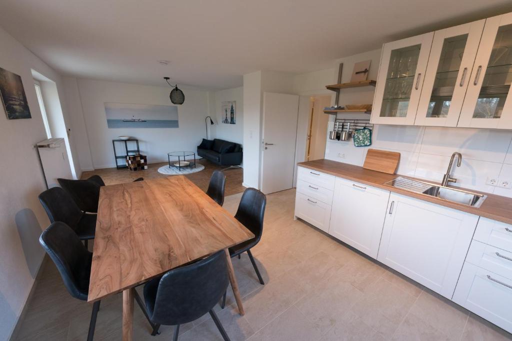 cocina y comedor con mesa de madera y sillas en Gästehaus Albero, en Lindau