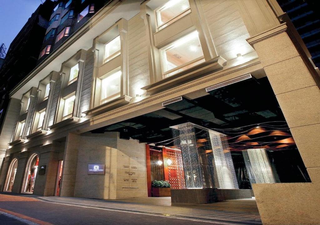 a building on the side of a street at night at The Luxe Manor in Hong Kong