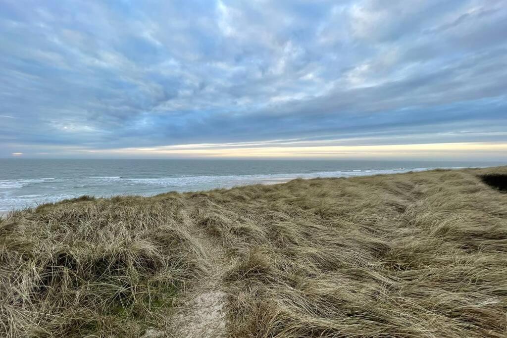 un campo de hierba junto a una playa con el océano en Kuscheliges Sylt Zuhause für 2 Personen en Westerland