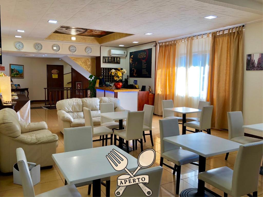 une chambre avec des tables et des chaises et un salon dans l'établissement Hotel La Perla Preziosa, à Grottammare