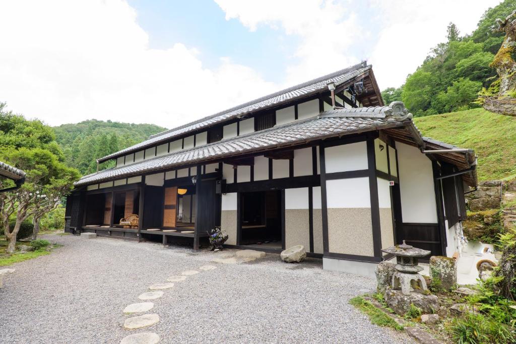 a black and white building with a hill in the background at The Ninja Mansion in Toyota
