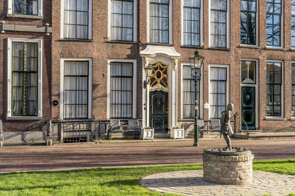 una estatua frente a un edificio de ladrillo en Job Baster Gastenverblijf, en Zierikzee