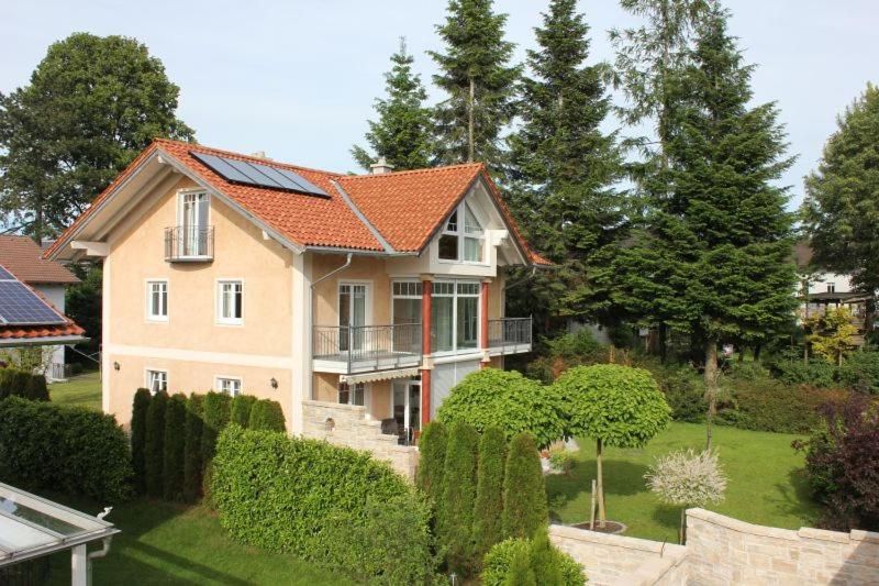 una casa con techo naranja y algunos arbustos en Ferienwohnung Wühn, en Teisendorf