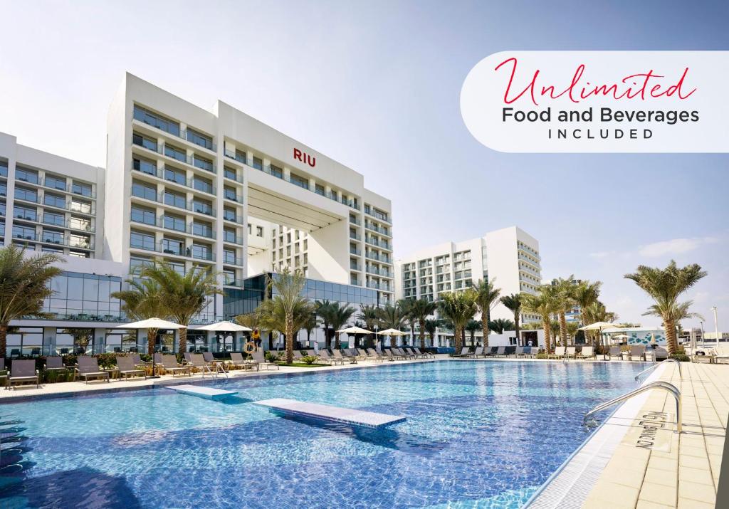 a hotel room with a swimming pool and a large swimming pool at Riu Dubai - All Inclusive in Dubai