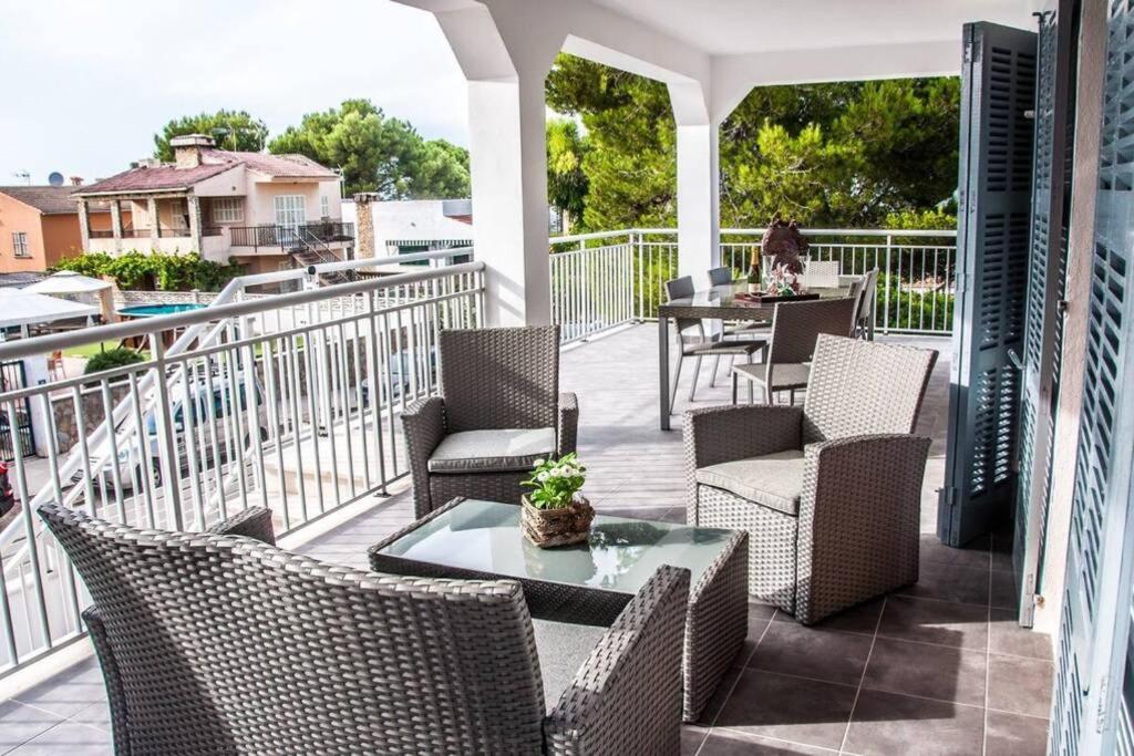 a patio with chairs and tables on a balcony at Villa Son Serra de Marina in Son Serra de Marina