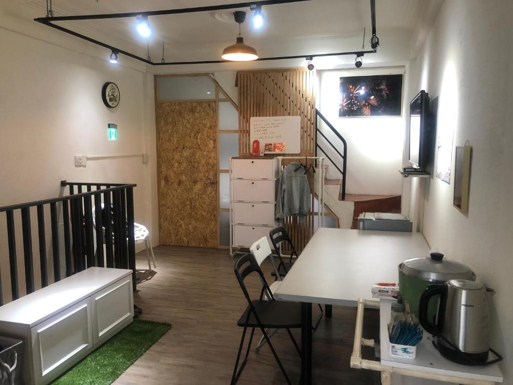 a room with a table and a room with a staircase at Simple Walk Guest House 小公寓 in Tainan