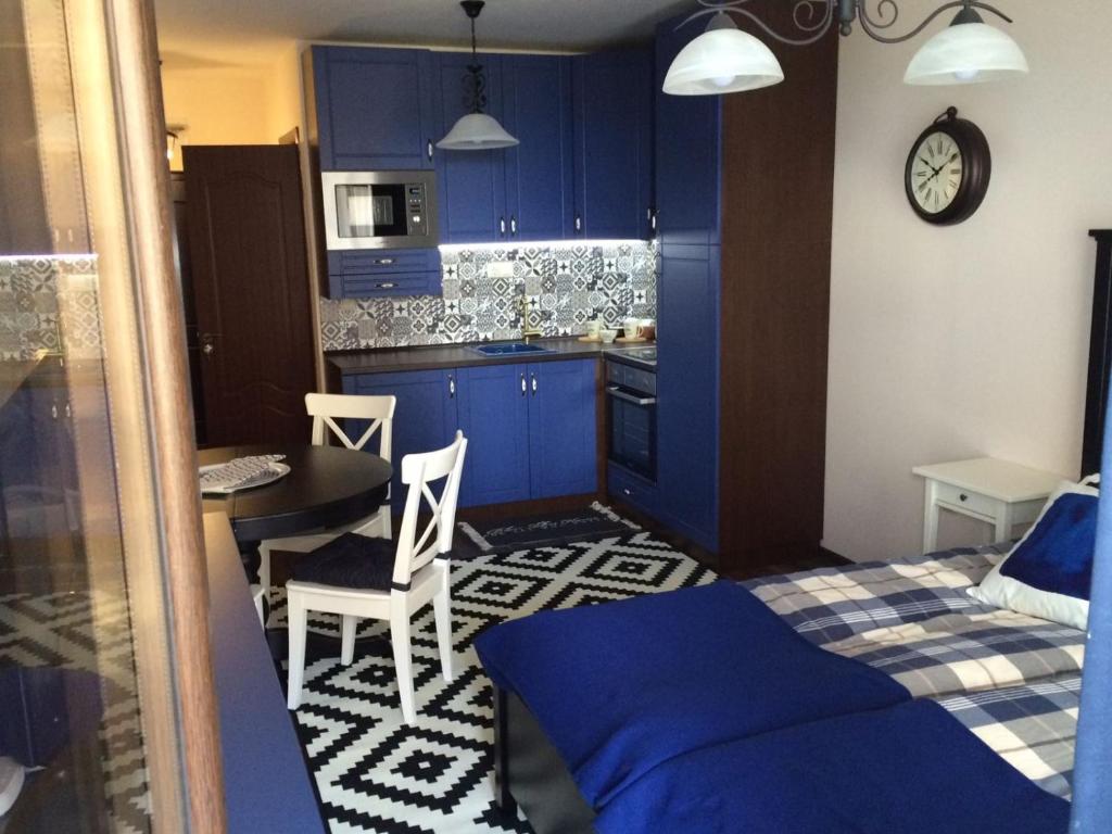 1 dormitorio con armarios azules y cocina con mesa en Apartment Perfect en Pomorie