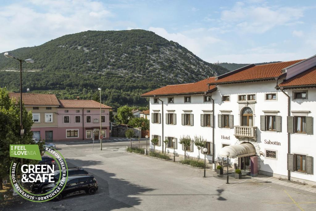 ein Auto, das auf einem Parkplatz neben einem Gebäude parkt in der Unterkunft Sabotin, Hotel & Restaurant in Nova Gorica