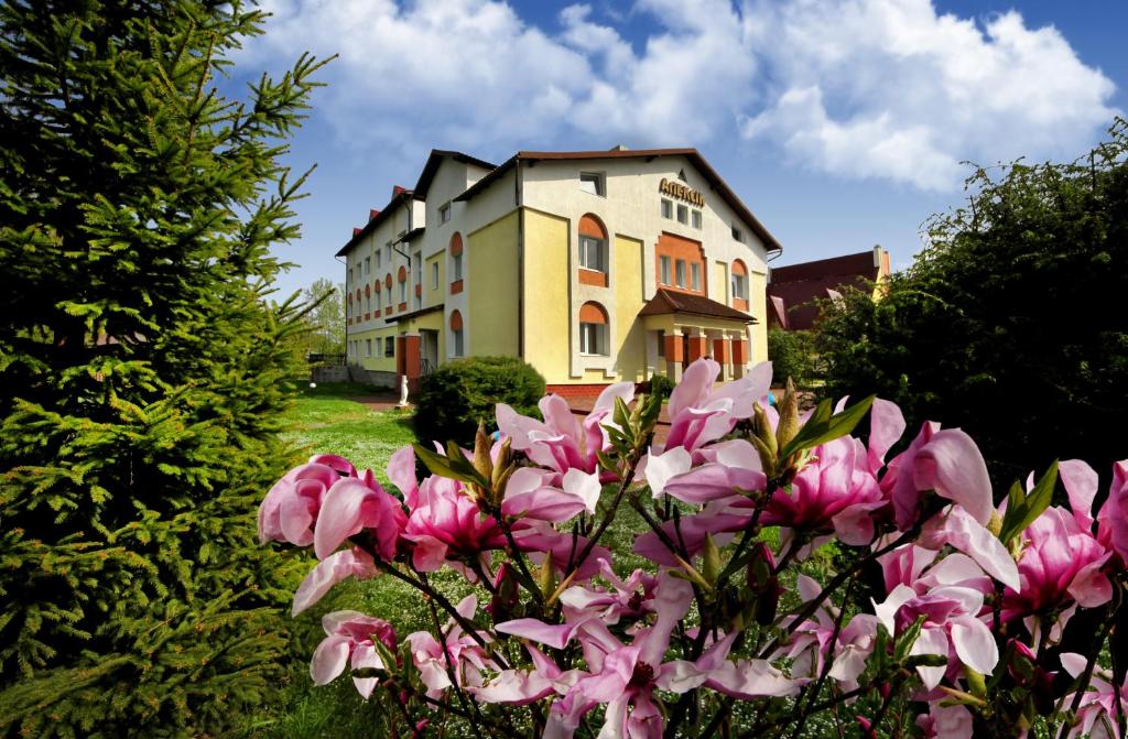 Una casa con flores rosas en el frente. en Алексік, en Truskavets